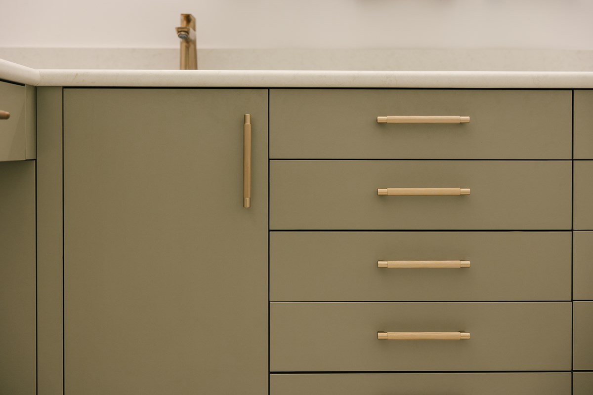 moss green melamine cabinetry with brass hardware